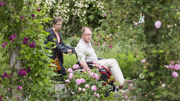 A couple of visitors surrounded by roses at Mottisfont, Hampshire
